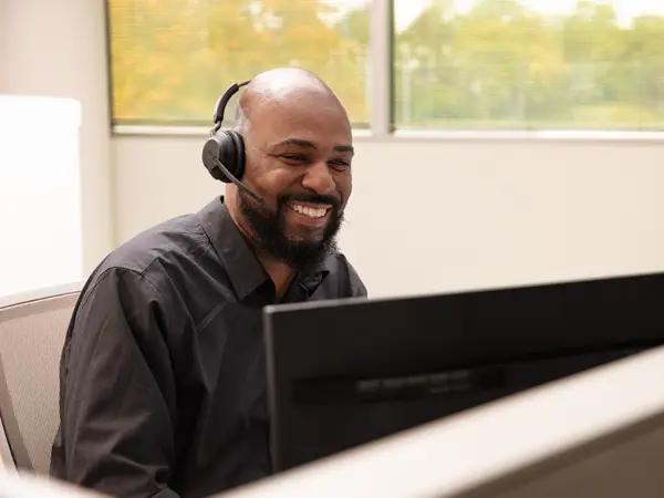 Smiling man with headphones working at laptop